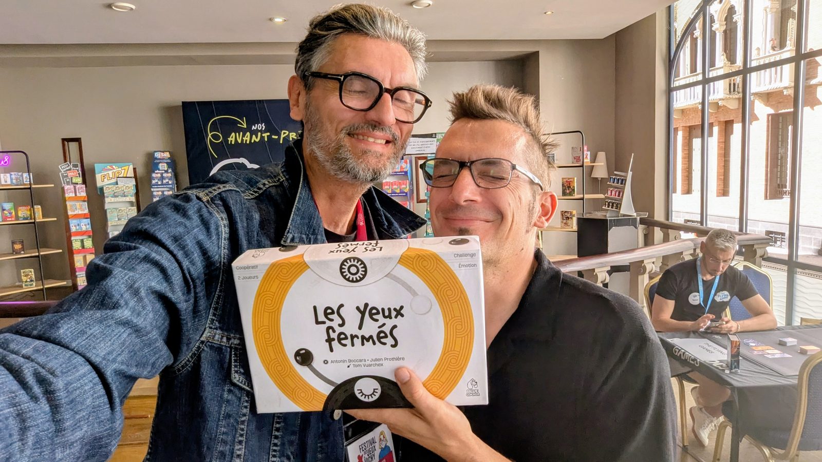 Cesare Mainardi avec Julien Prothière tenant la boîte du jeu Les Yeux fermés